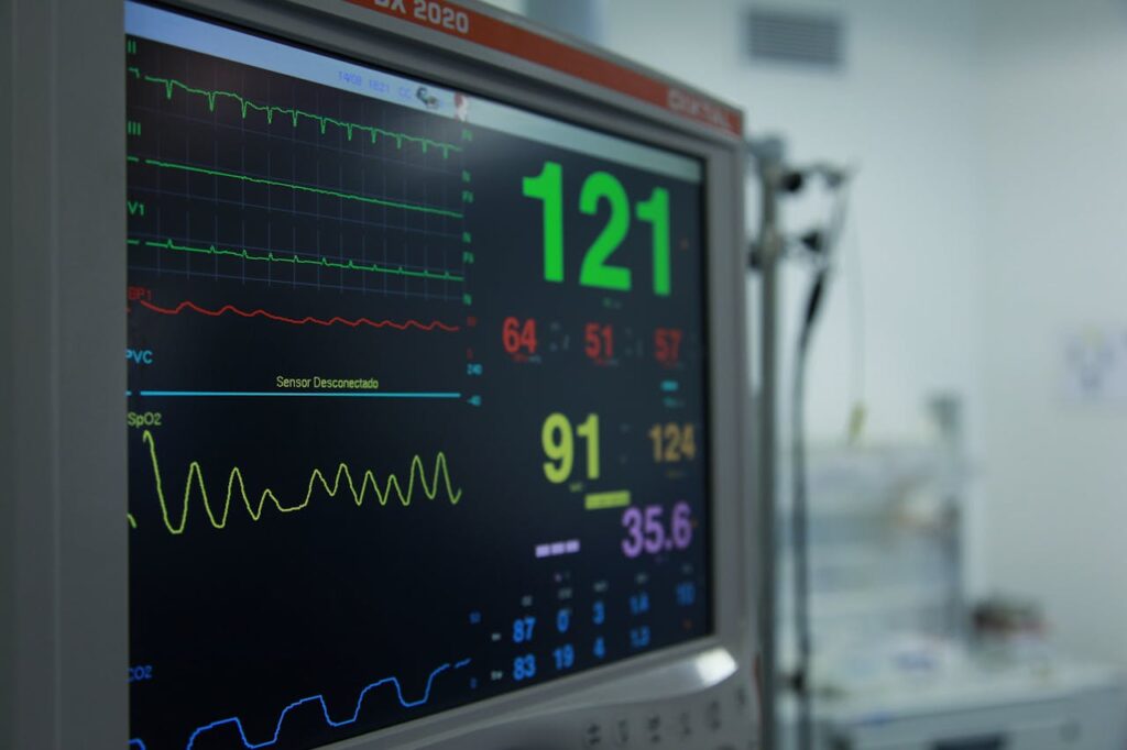 Close-up view of a vital signs monitor showing various medical readings in a hospital setting.