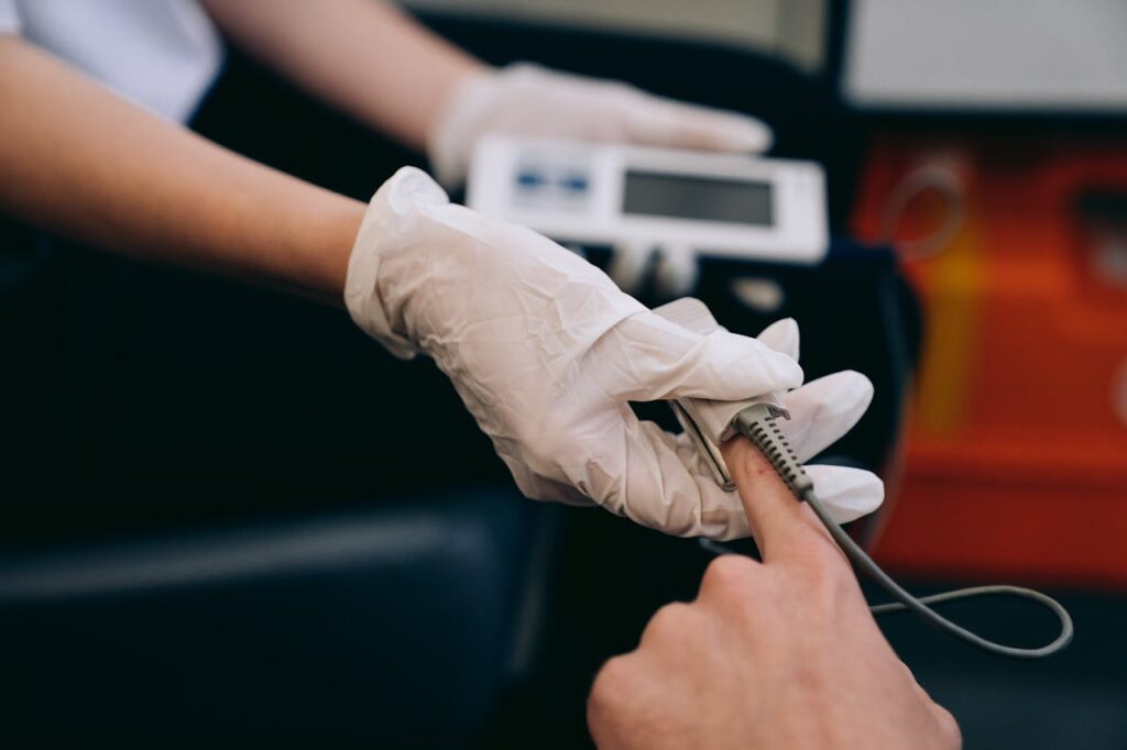 Close-up of a healthcare professional using a pulse oximeter on a patient's finger to monitor vital signs.